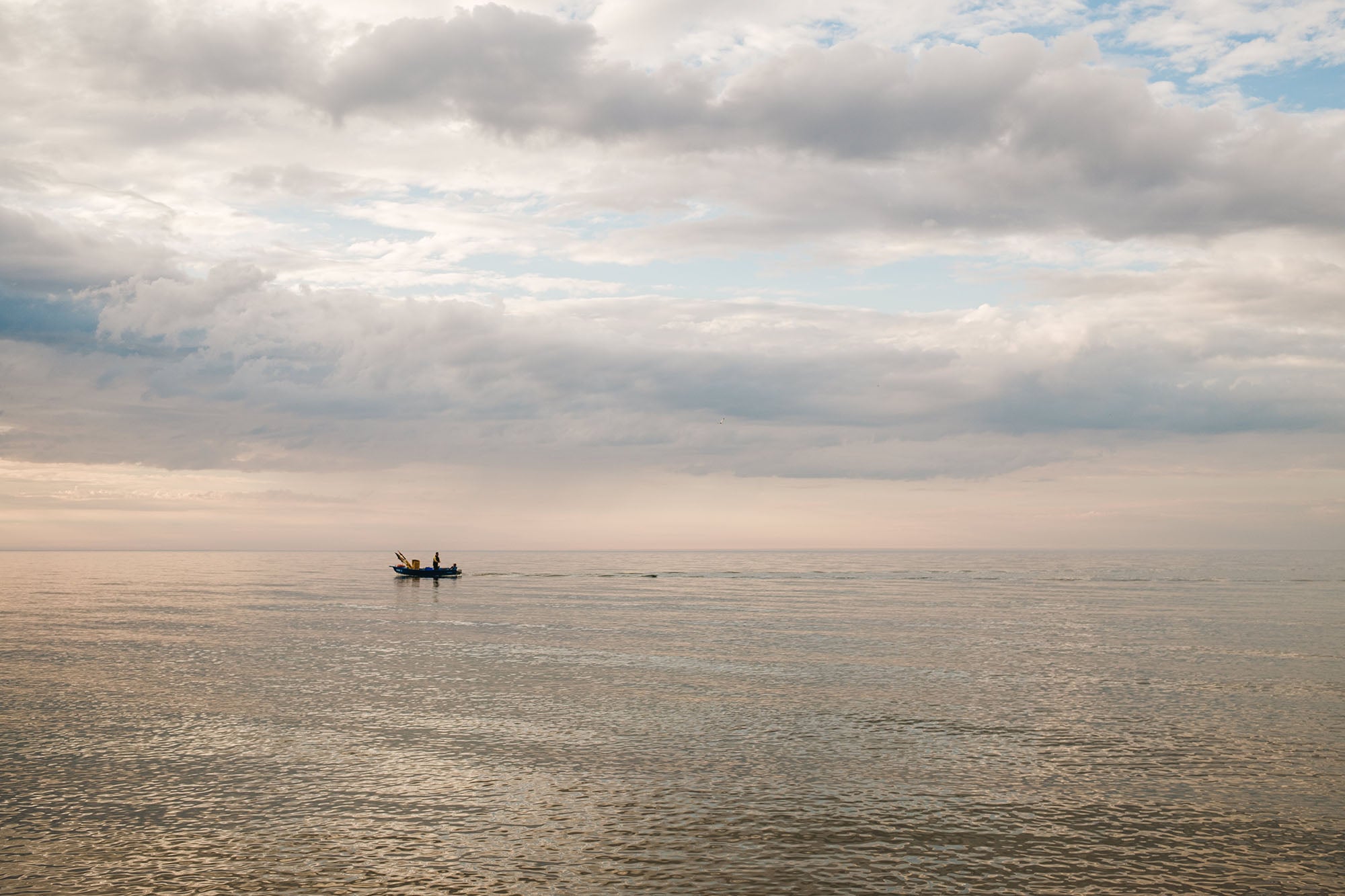 Boat on a calm sea under a cloudy sky
