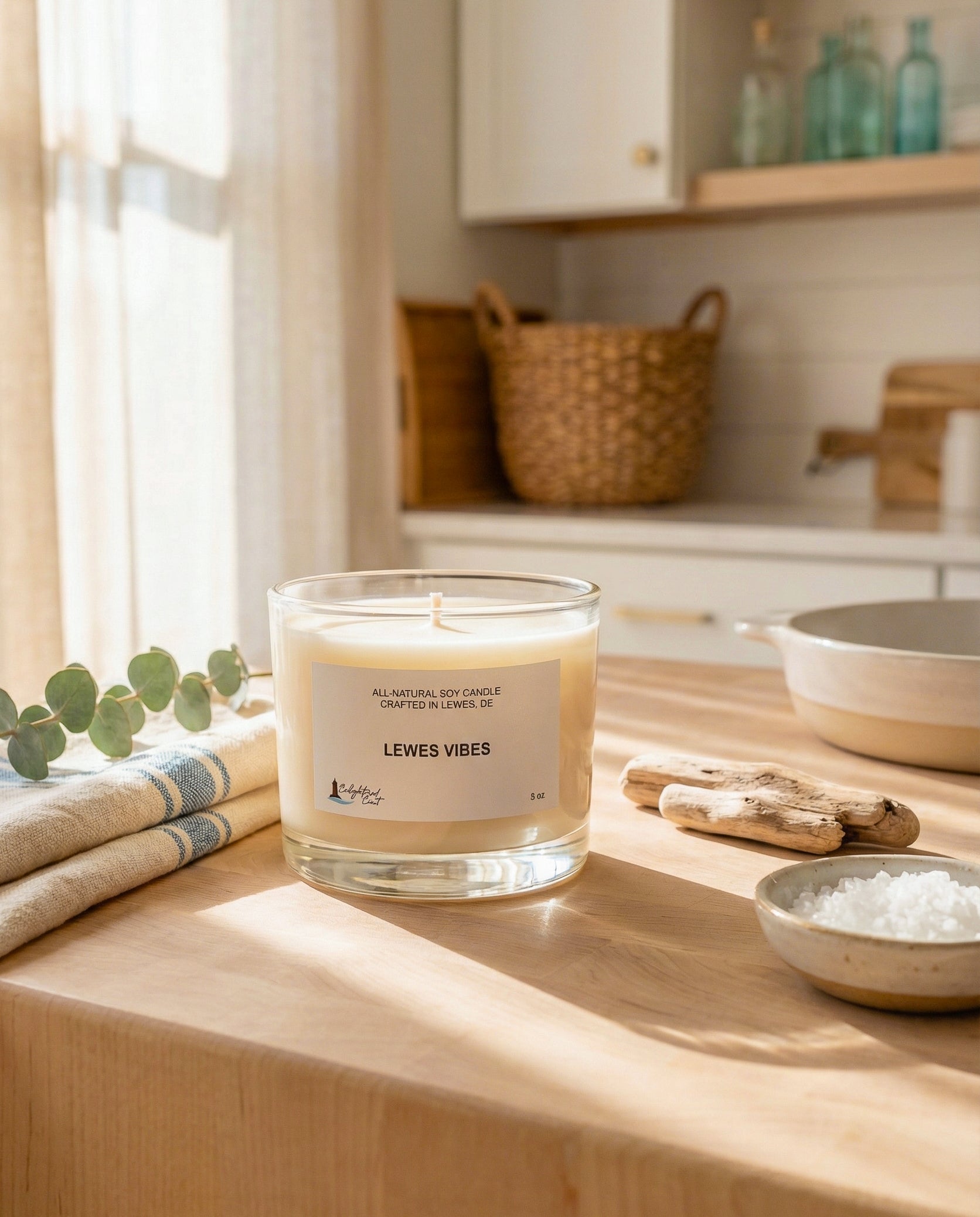 Candle labeled 'Lewes Vibes' on a wooden surface with a kitchen background