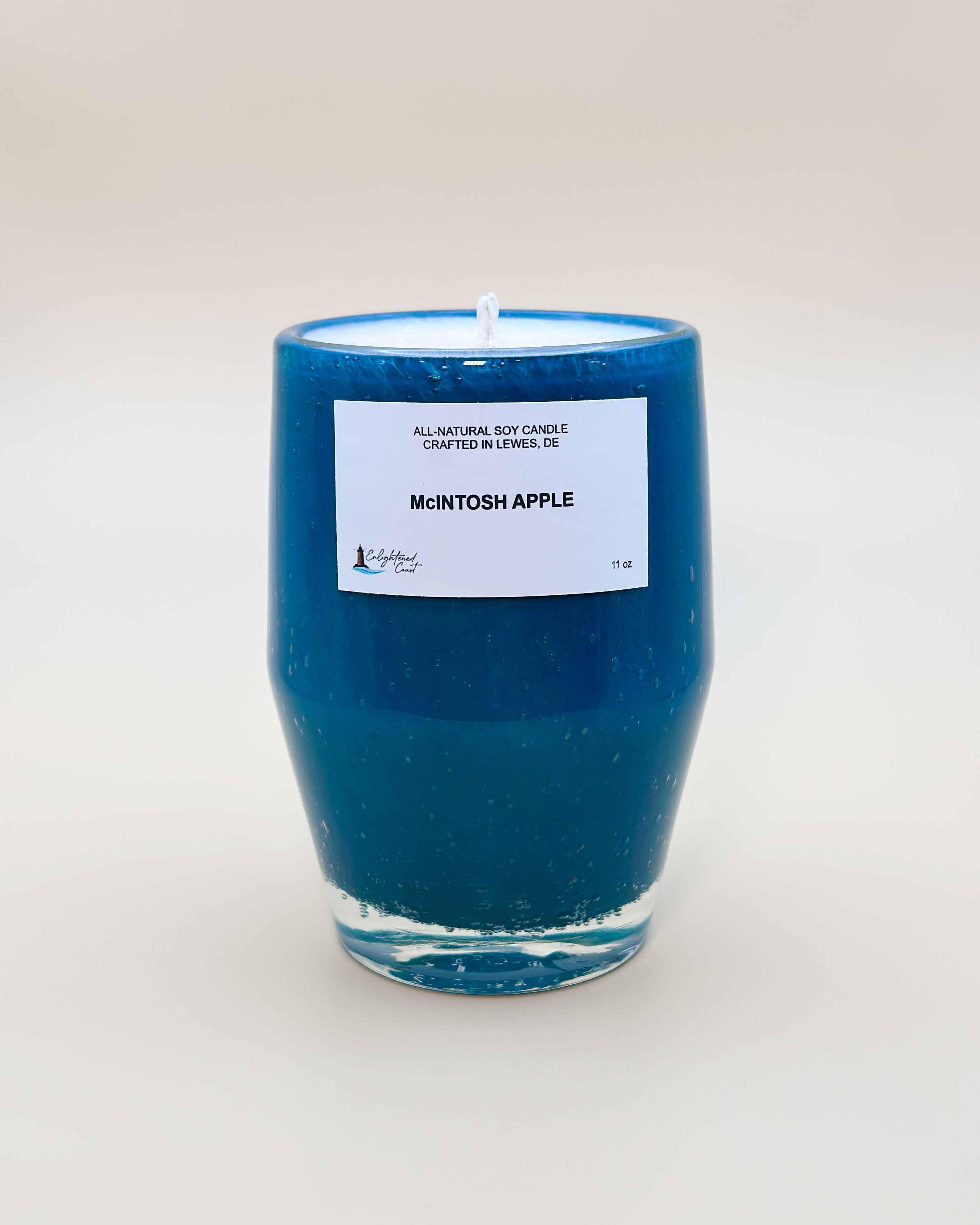 Teal candle with a white McIntosh Apple label