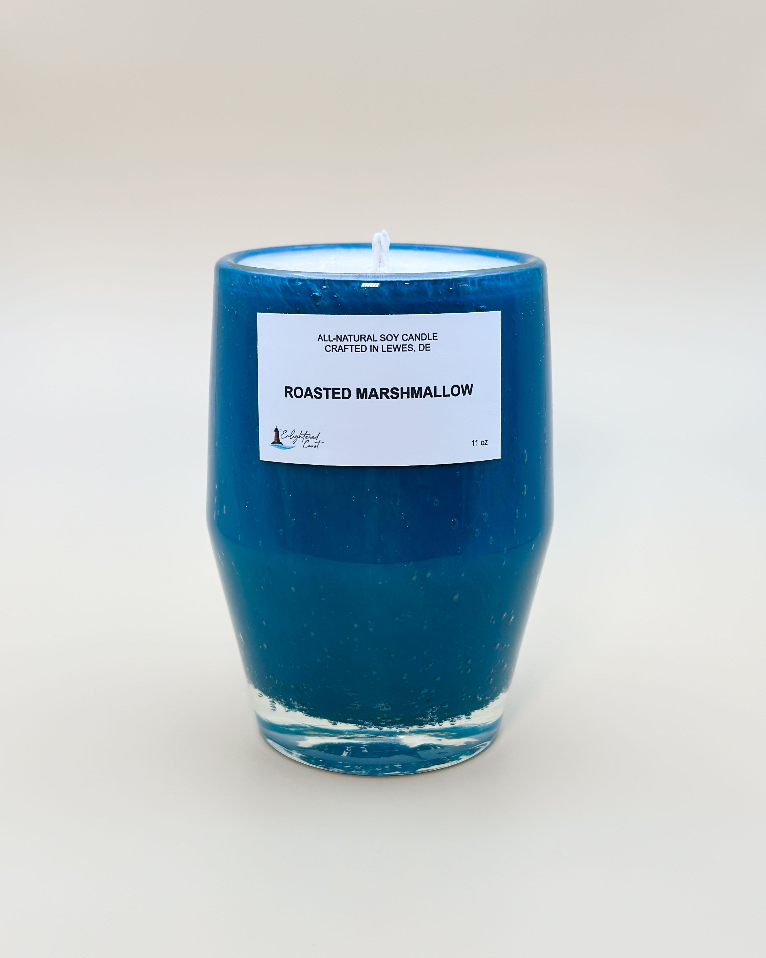 Teal candle with a white Roasted Marshmallow label
