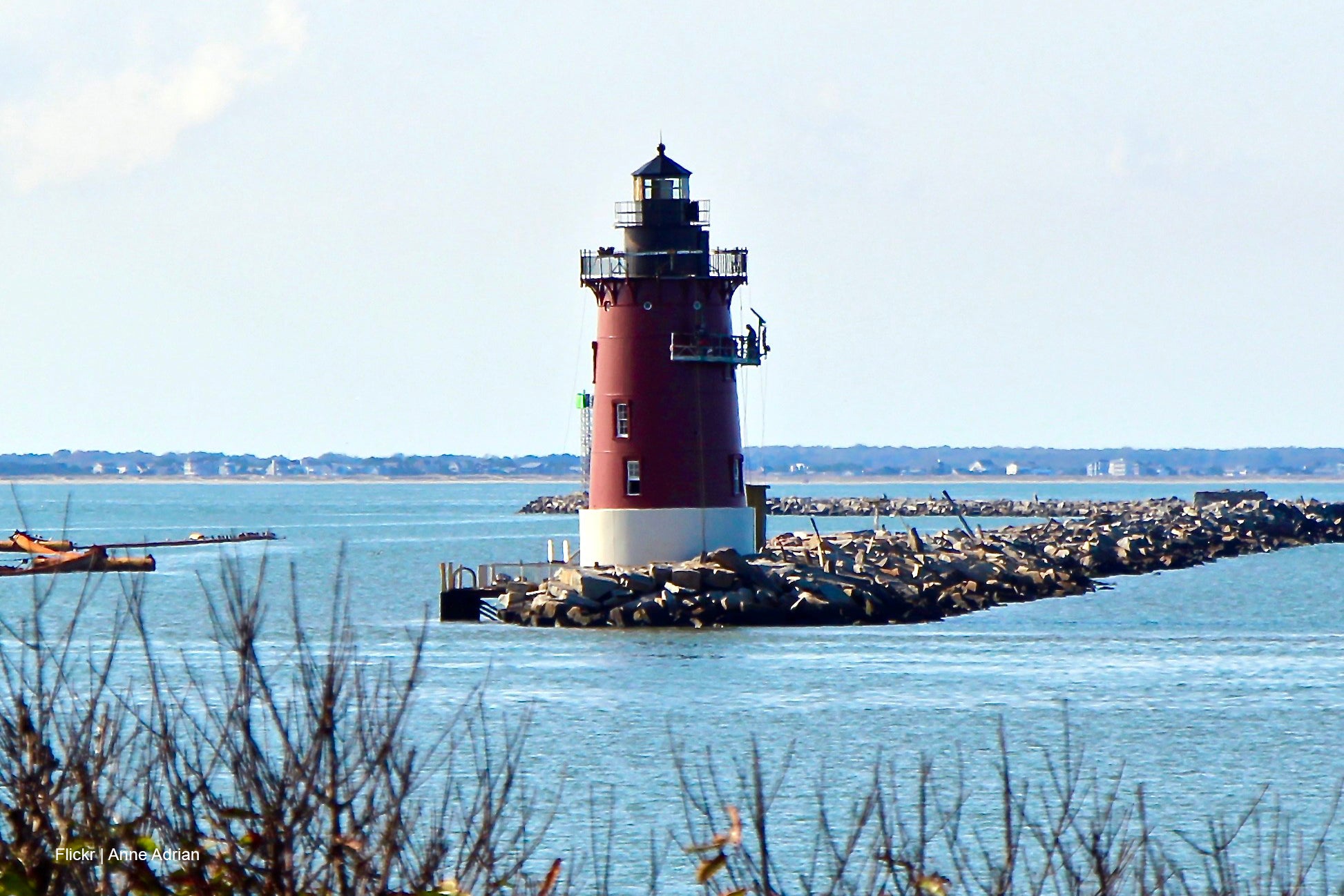 Lewes Lighthouse on a rocky breakwater with water and sky in the background