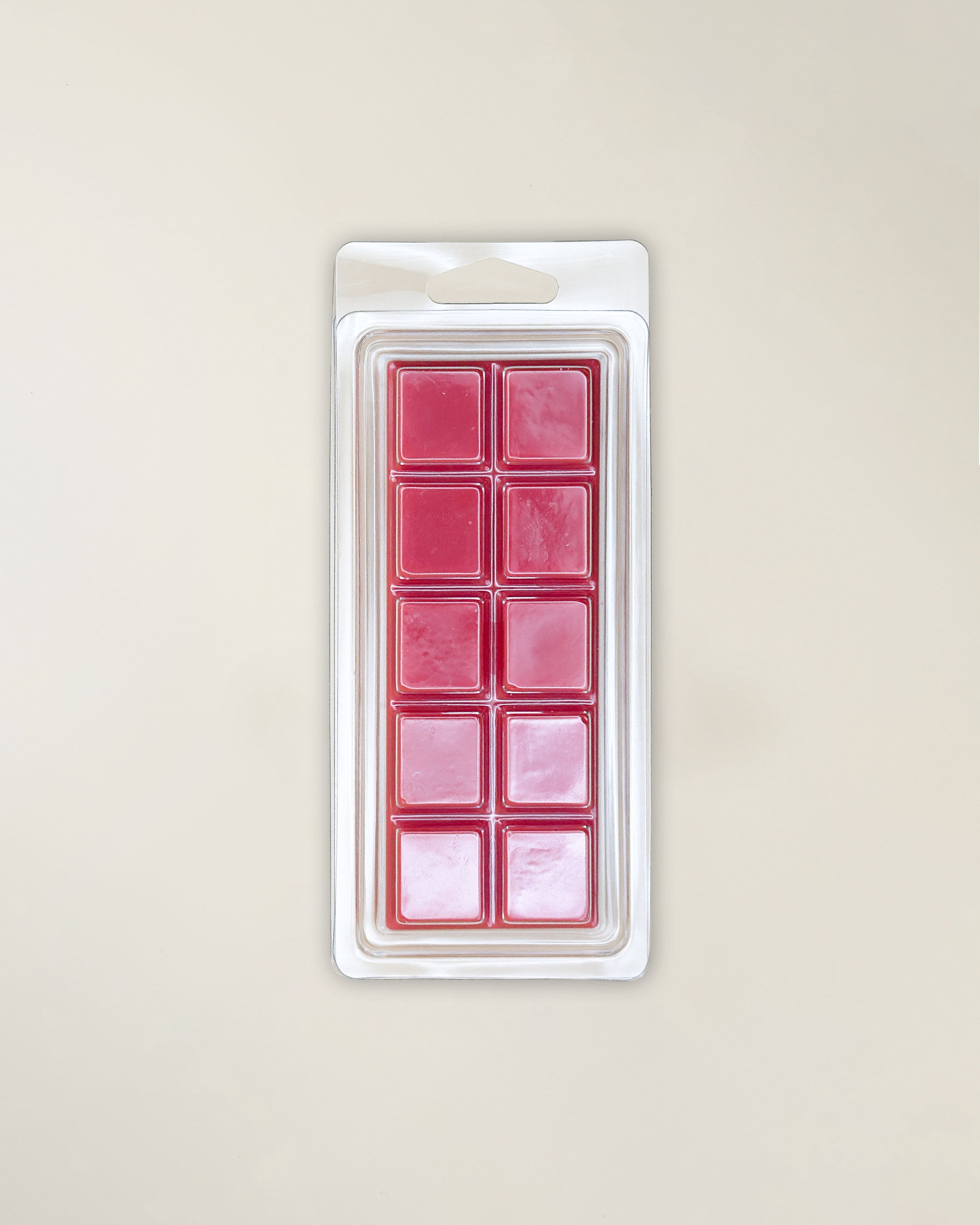 Packaged red wax melts on a beige background