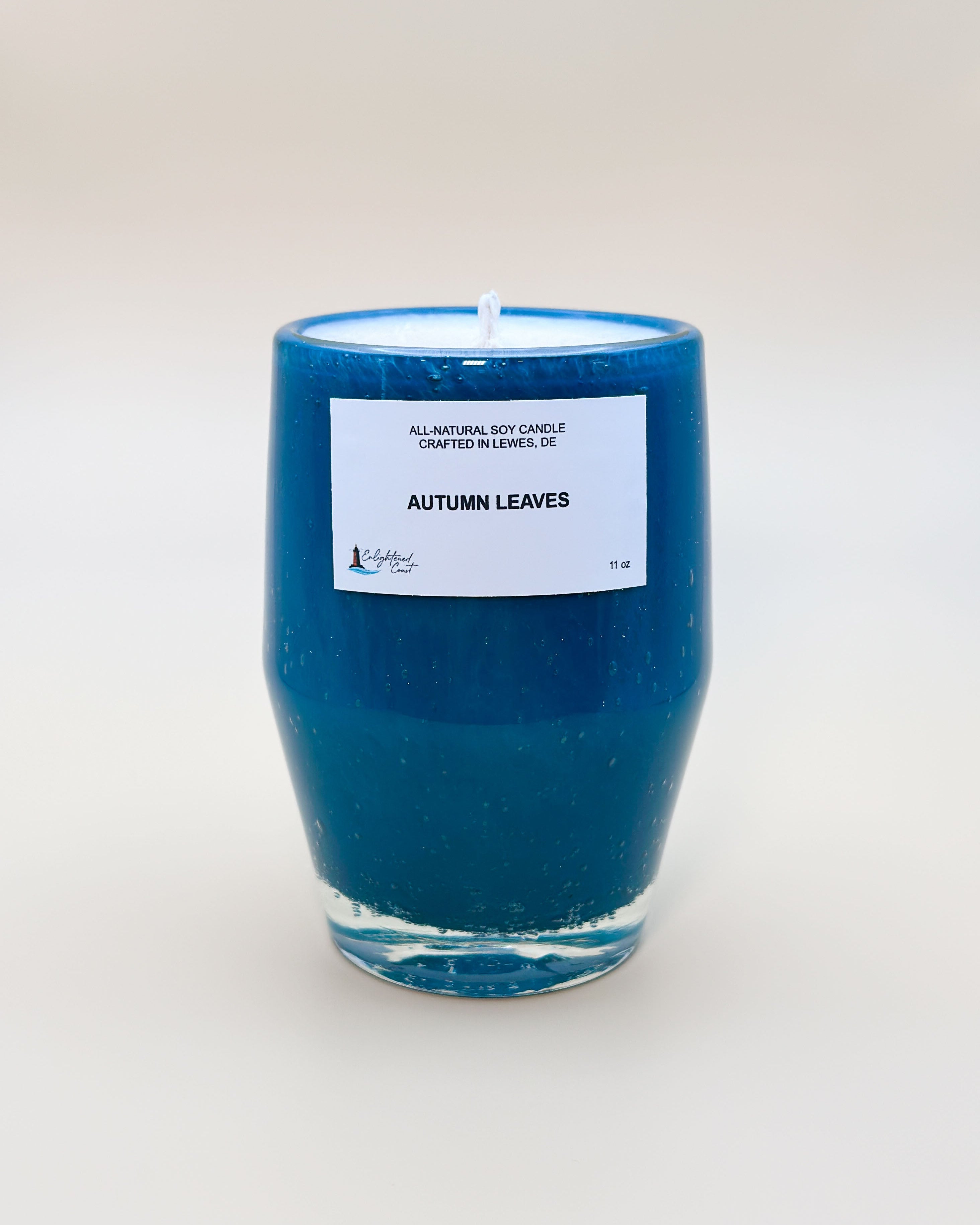 Teal candle with a white Autumn Leaves label