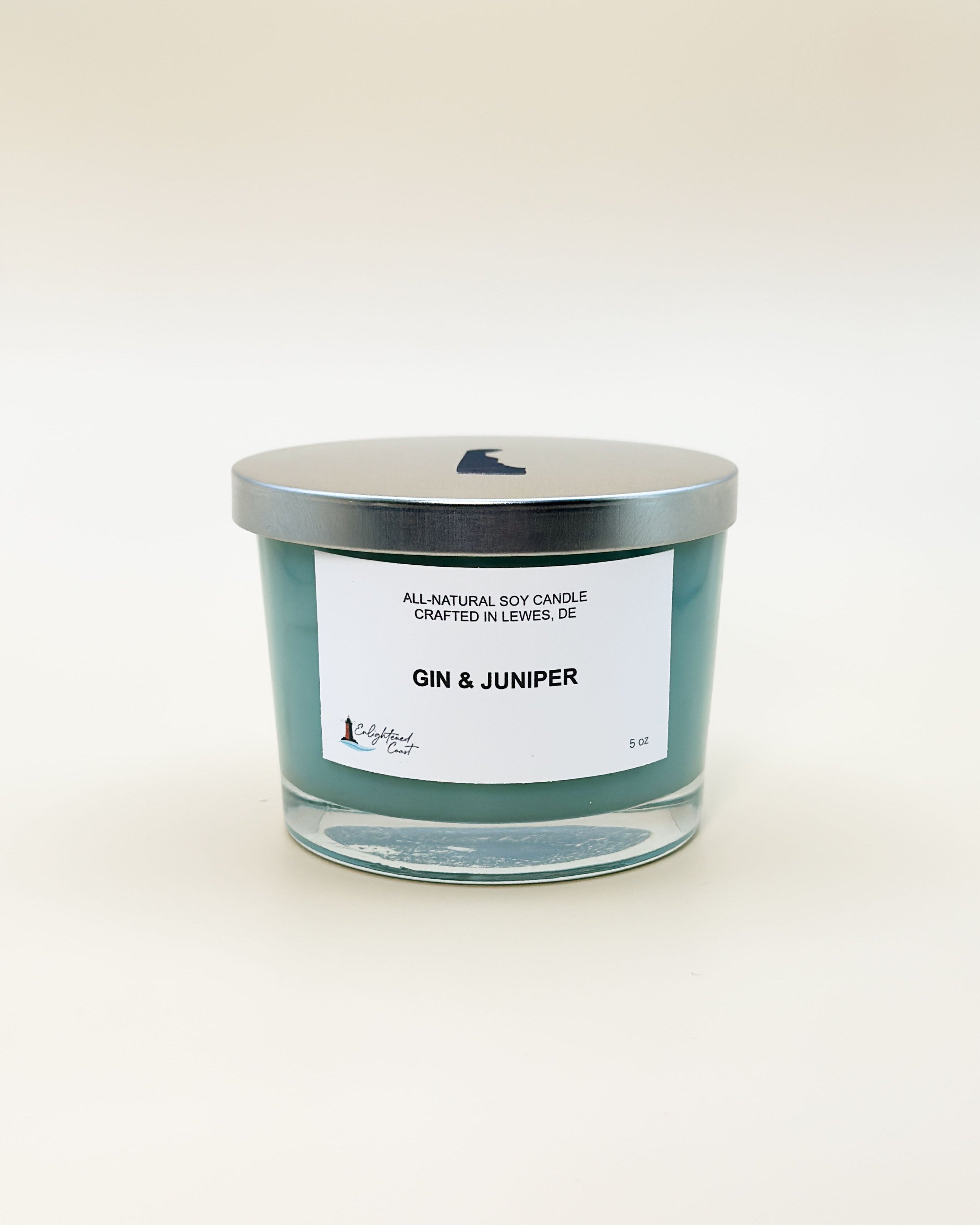 Candle labeled 'Gin & Juniper' with a silver lid on a white background