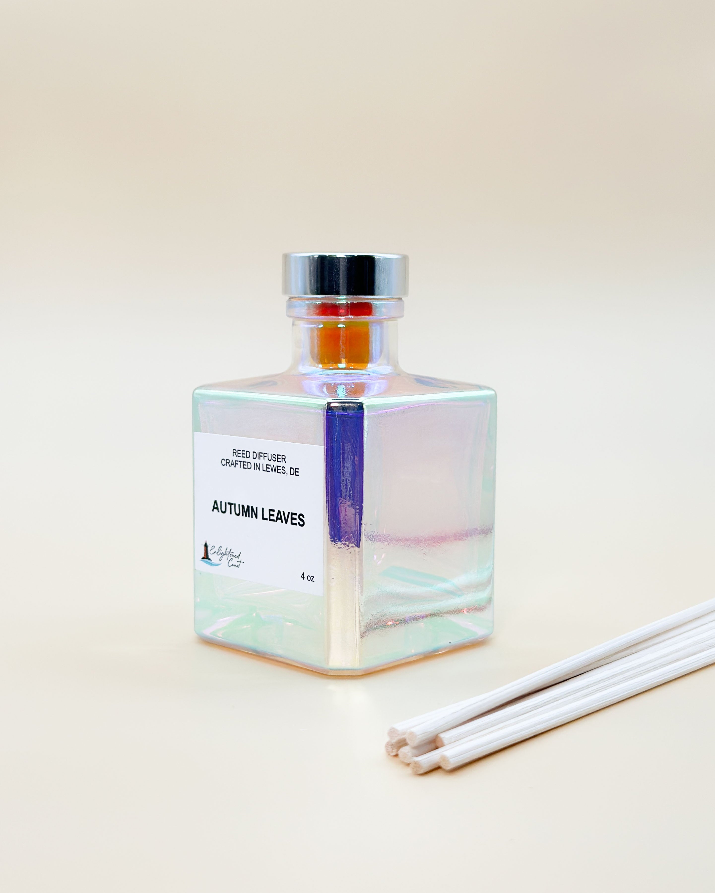 Square glass diffuser bottle labeled 'Autumn Leaves' with  sticks on a light beige background