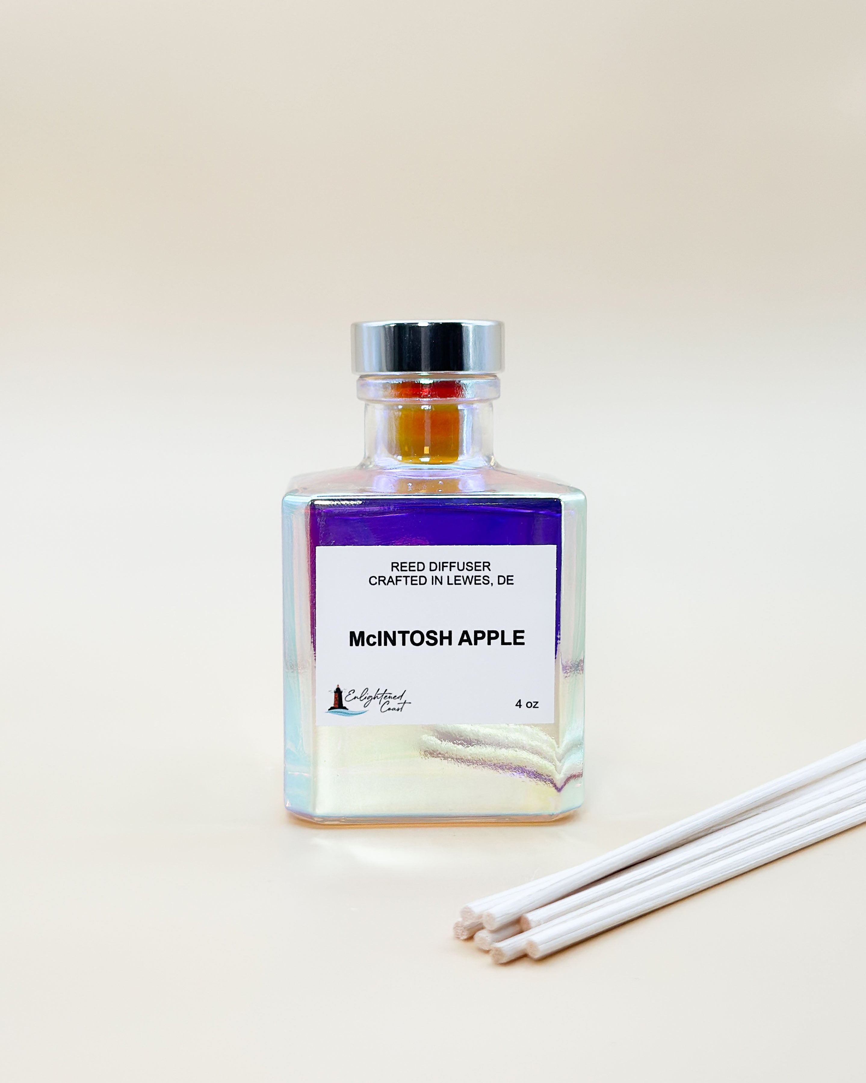 Reed diffuser bottle labeled 'McIntosh Apple' with reeds on a light background