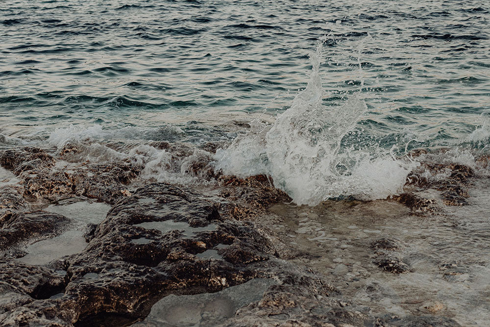 Wave crashing onto rocks with water splashing up